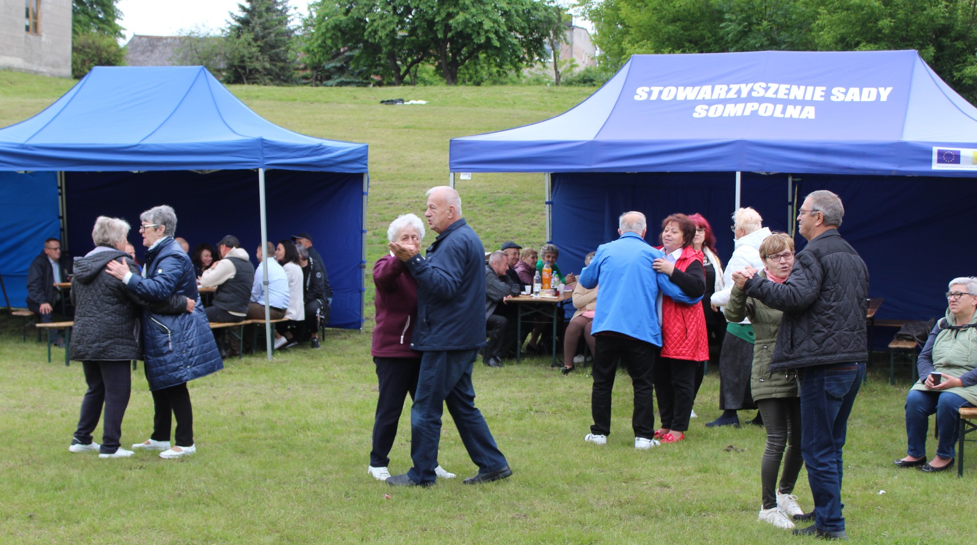 Zdjęcie wykonane podczas zabawy tanecznej na Majówce Seniora, na której seniorzy tańczą w parach.