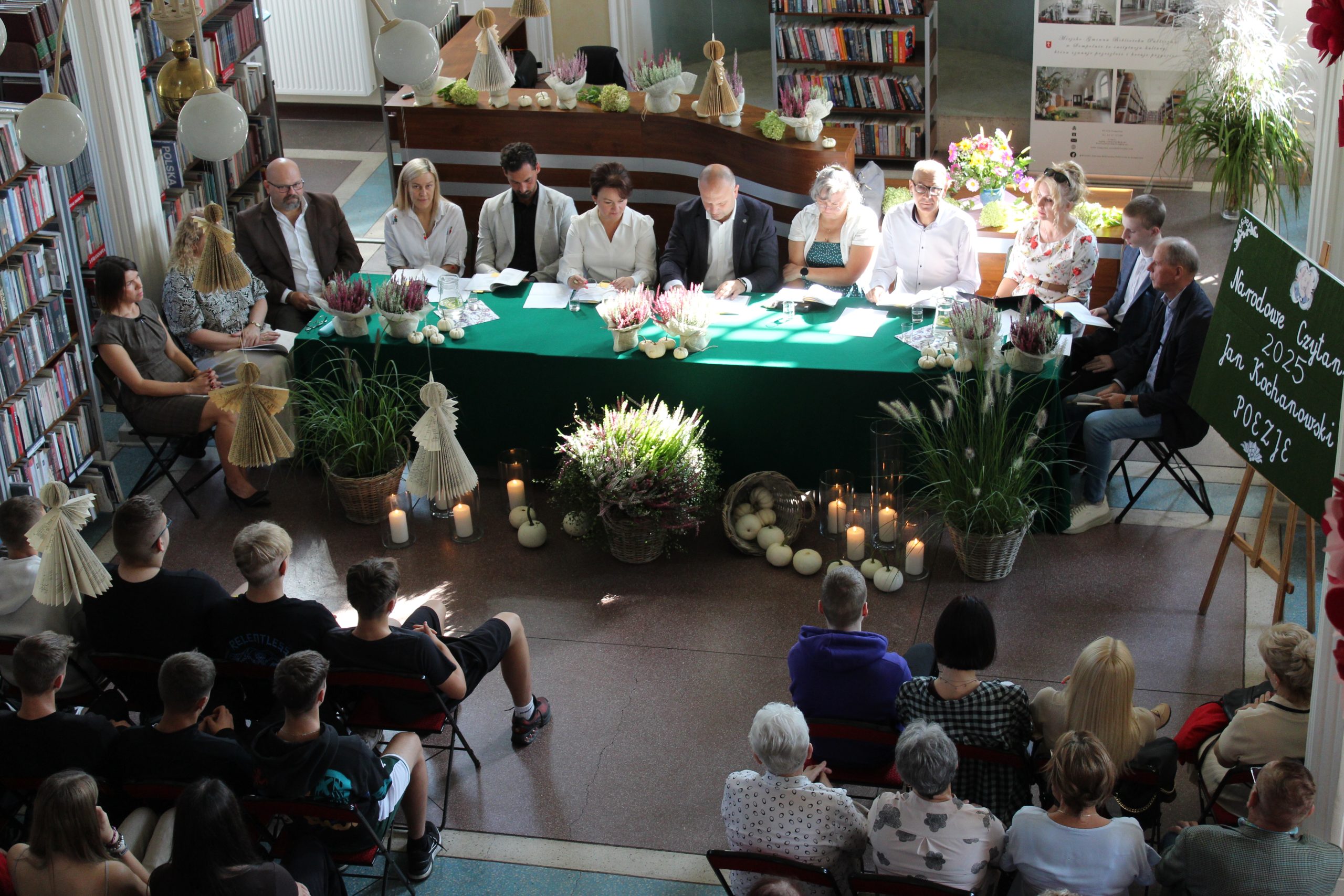 Na fotografii osoby czytające siedzące przy stole podczas narodowego czytania