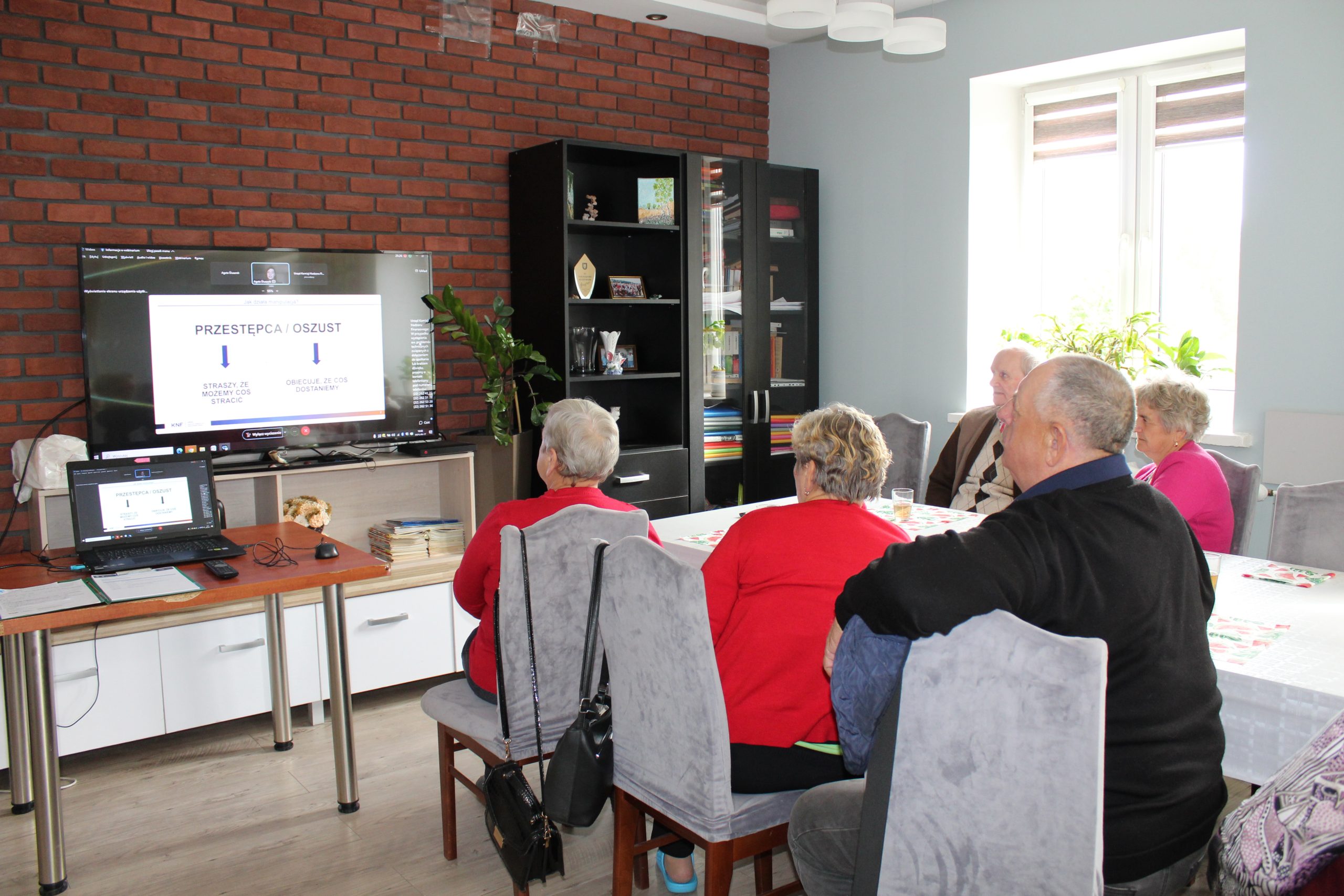 Zdjęcie wykonane w Domu Dziennego Pobytu Senior+ w Sompolnie. Przedstawia grupę uczestników podczas webinarium na temat bezpieczeństwa w internecie