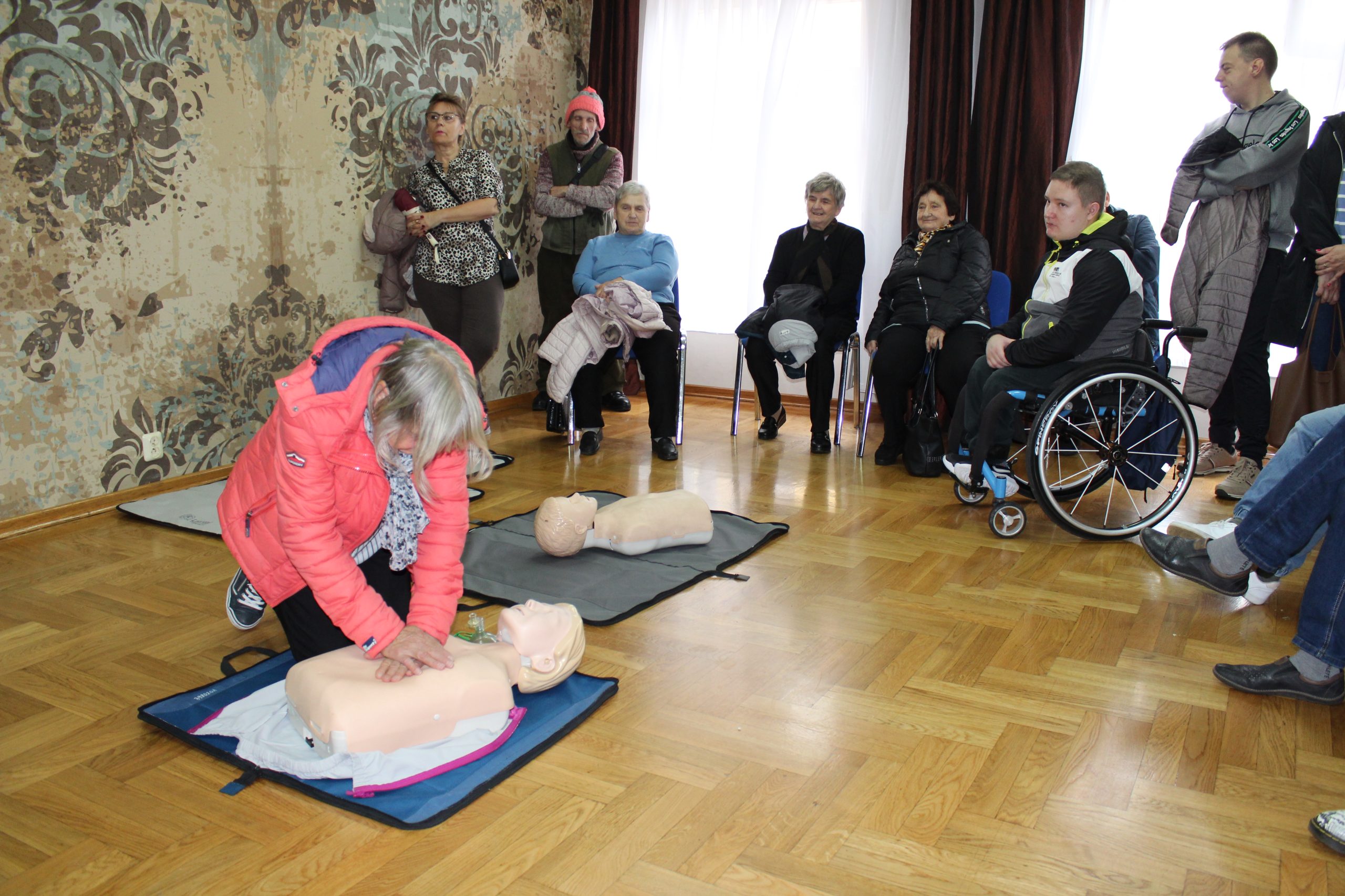 4) Zdjęcie przedstawia uczestniczkę spotkania, która ćwiczy na fantomie umiejętność wykonania resuscytacji krążeniowo-oddechowej