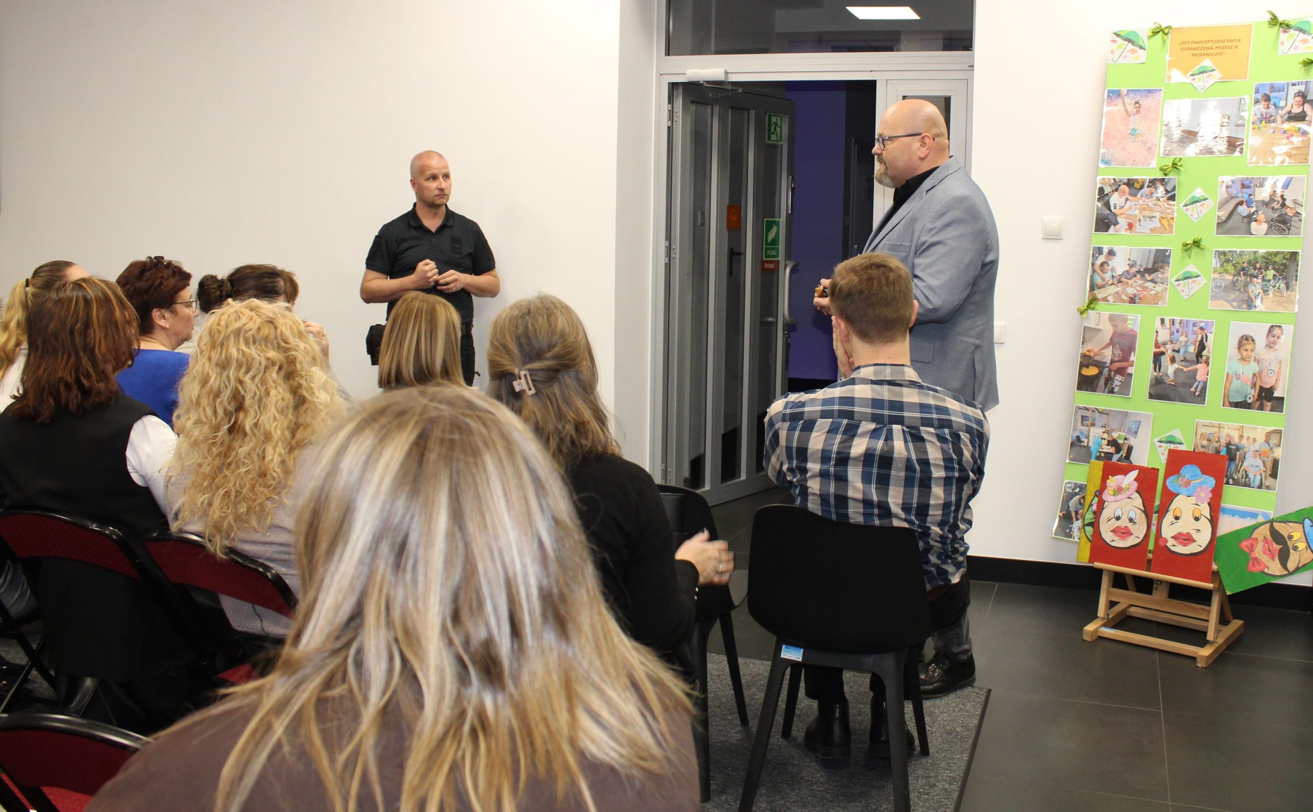 1) Zdjęcie zrobione w Dziennym Centrum Wsparcia w Sompolnie. Przedstawia: z prawej strony – pana Tomasza Majewskiego (dyrektora Miejsko – Gminnego Ośrodka Pomocy Społecznej w Sompolnie), z lewej strony – pana Pawła Boguszewskiego ( detektywa, mediatora, kuratora zajmującego się trudną młodzieżą). Na zdjęciu widać również osoby zebrane na spotkaniu.
