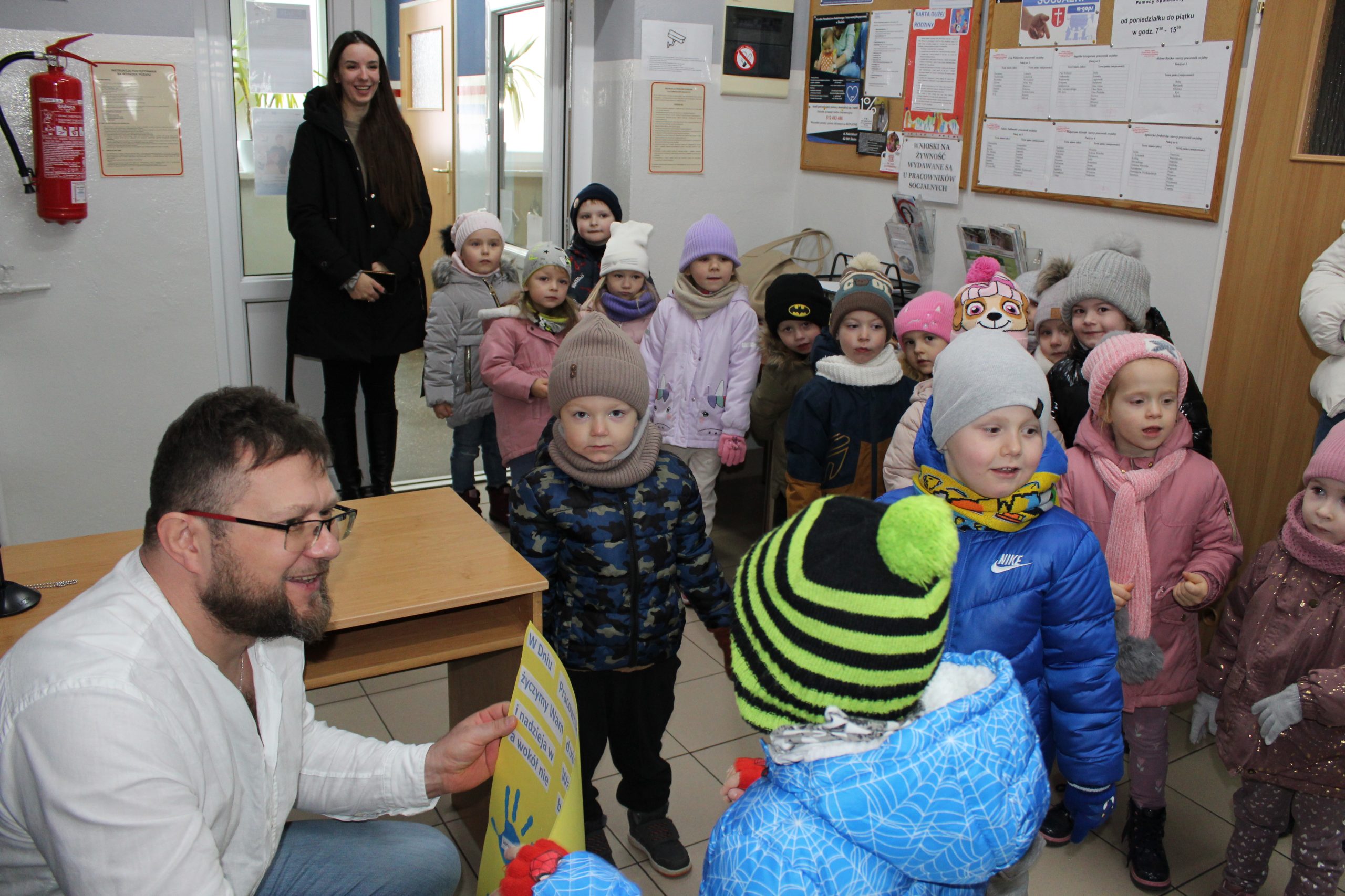 Na fotografii dzieci wręczające pracownikom laurkę z okazji dnia pracownika socjalnego.