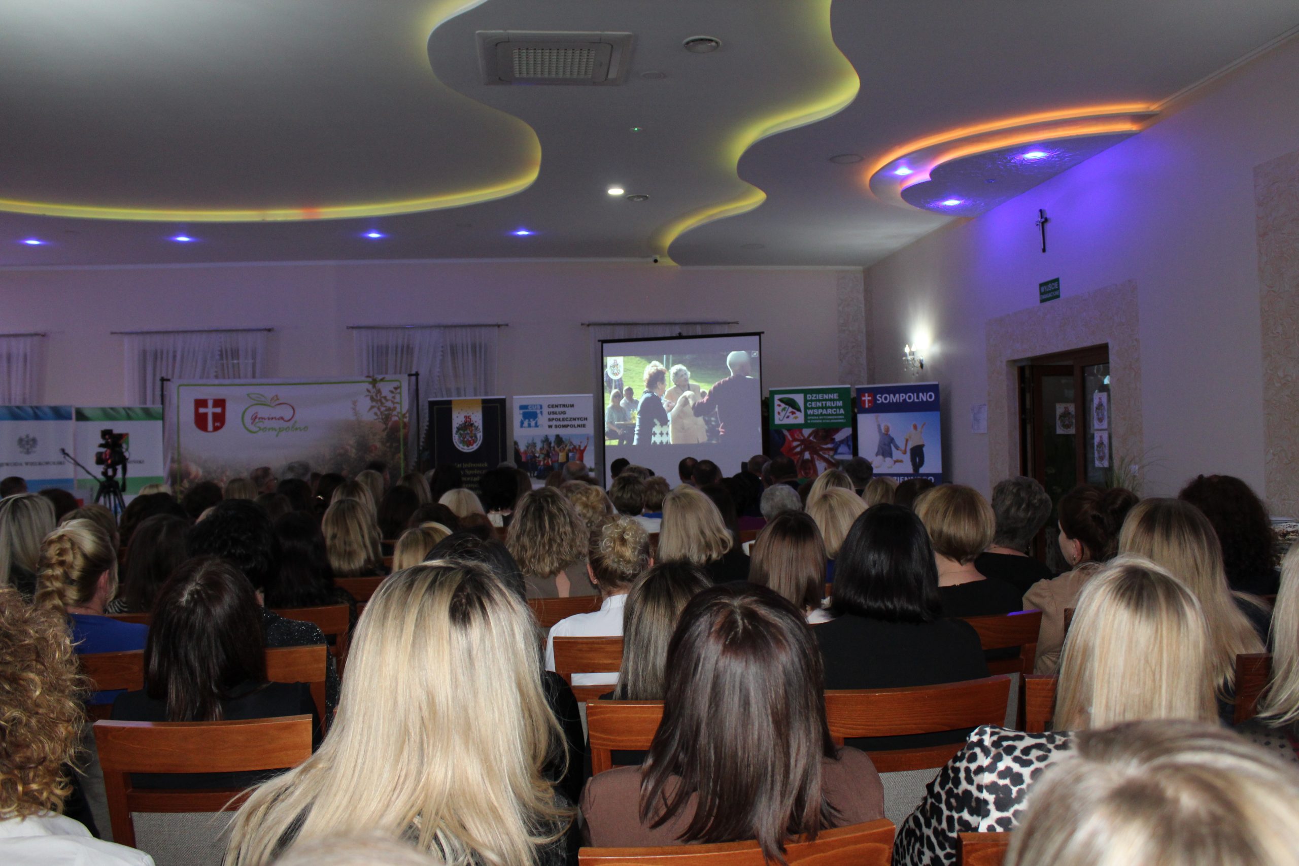 3) Zdjęcie przedstawia pracowników oglądających film o pracy ośrodków pomocy społecznej