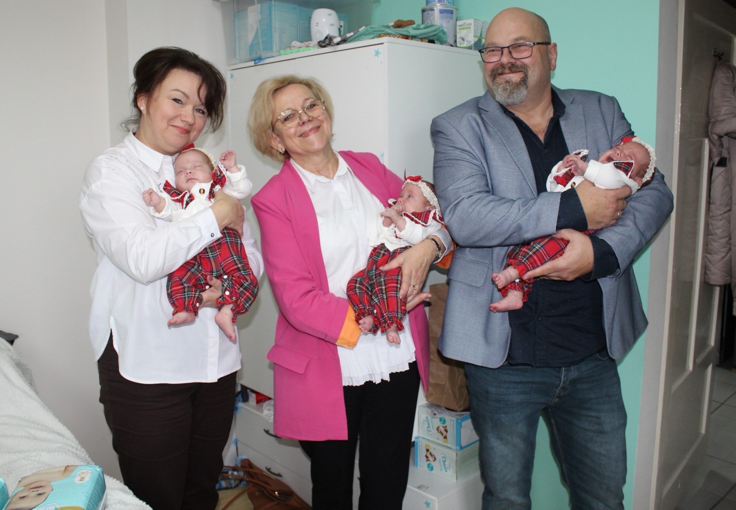 6) Zdjęcie przedstawia przedstawicieli urzędu trzymających na ręcach trojaczki.