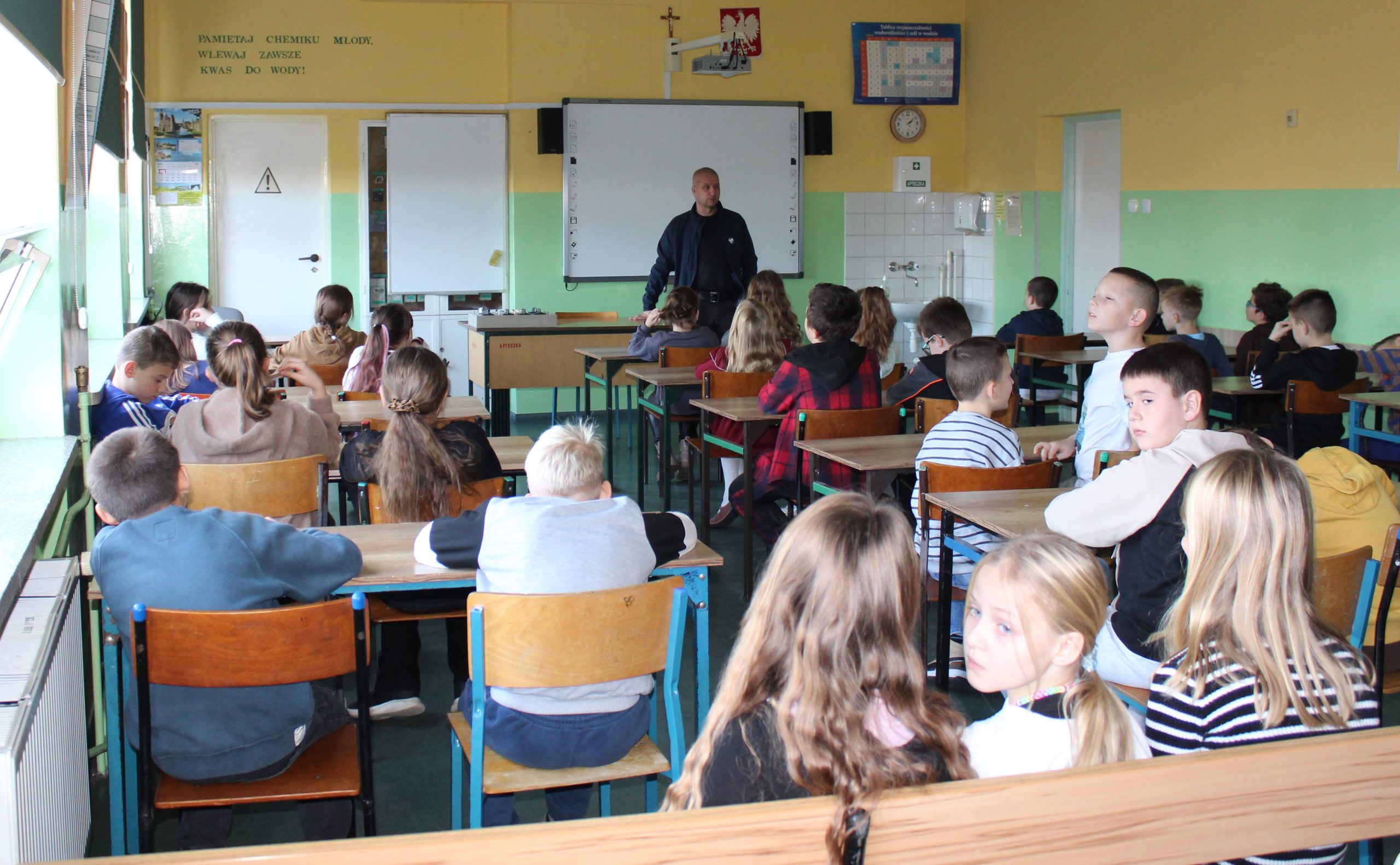 1) Zdjęcie wykonane w jednej z sal lekcyjnych w szkole podstawowej w Sompolnie. Przedstawia uczniów szkoły oraz Pana Pawła Boguszewskiego podczas prelekcji na temat hejtu wśród dzieci i młodzieży.