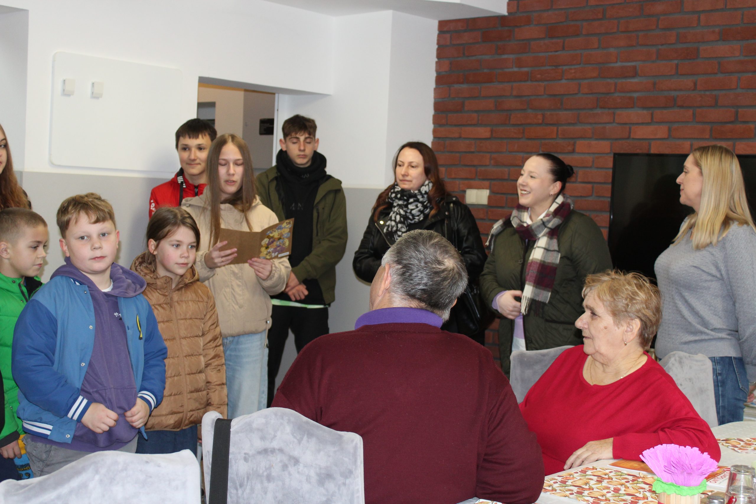 2) Na zdjęciu jedna z uczennic czyta życzenia z okazji Dnia Seniora.