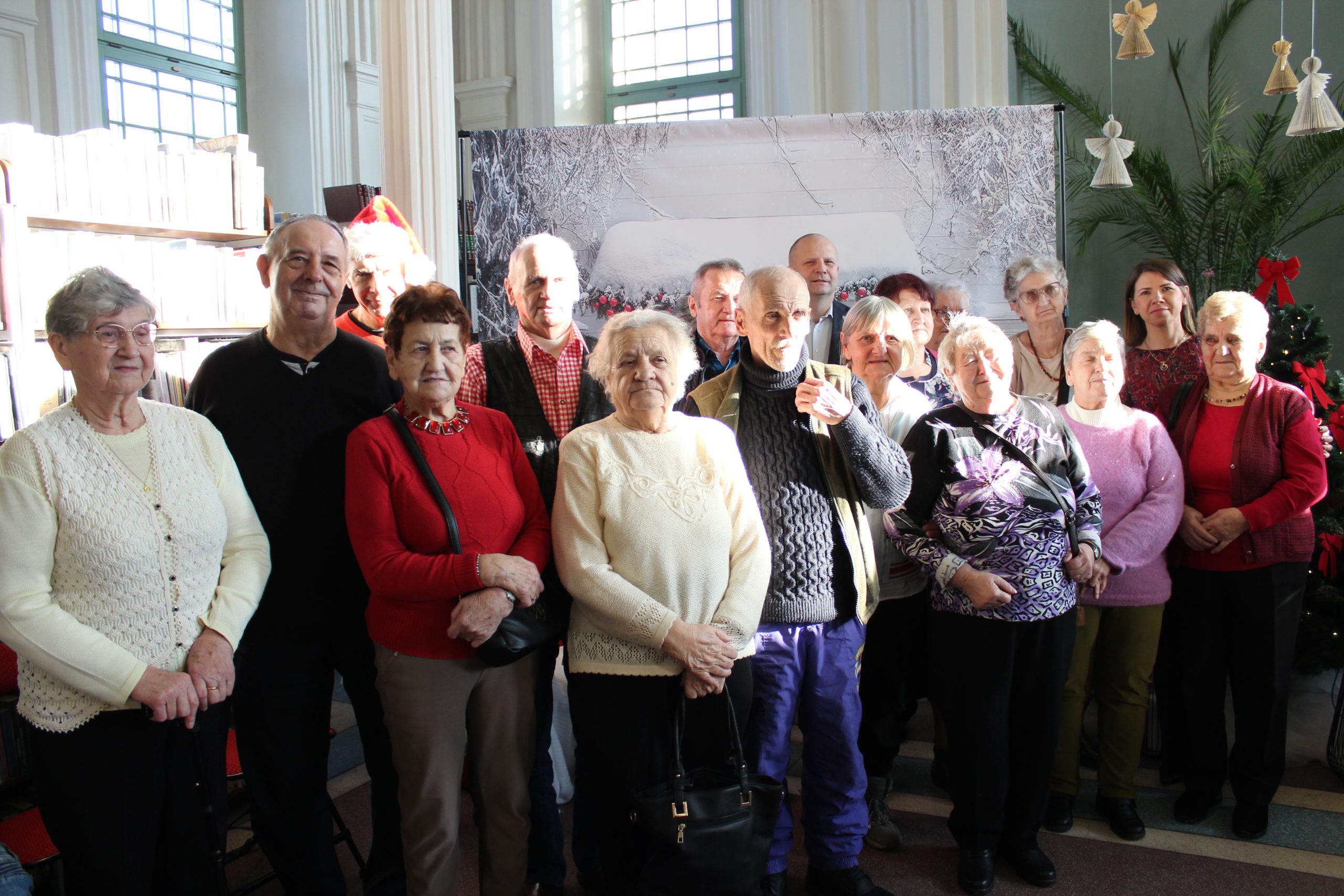 3) Zdjęcie grupowe przedstawia seniorów z DDP wraz z burmistrzem oraz panią dyrektor biblioteki.