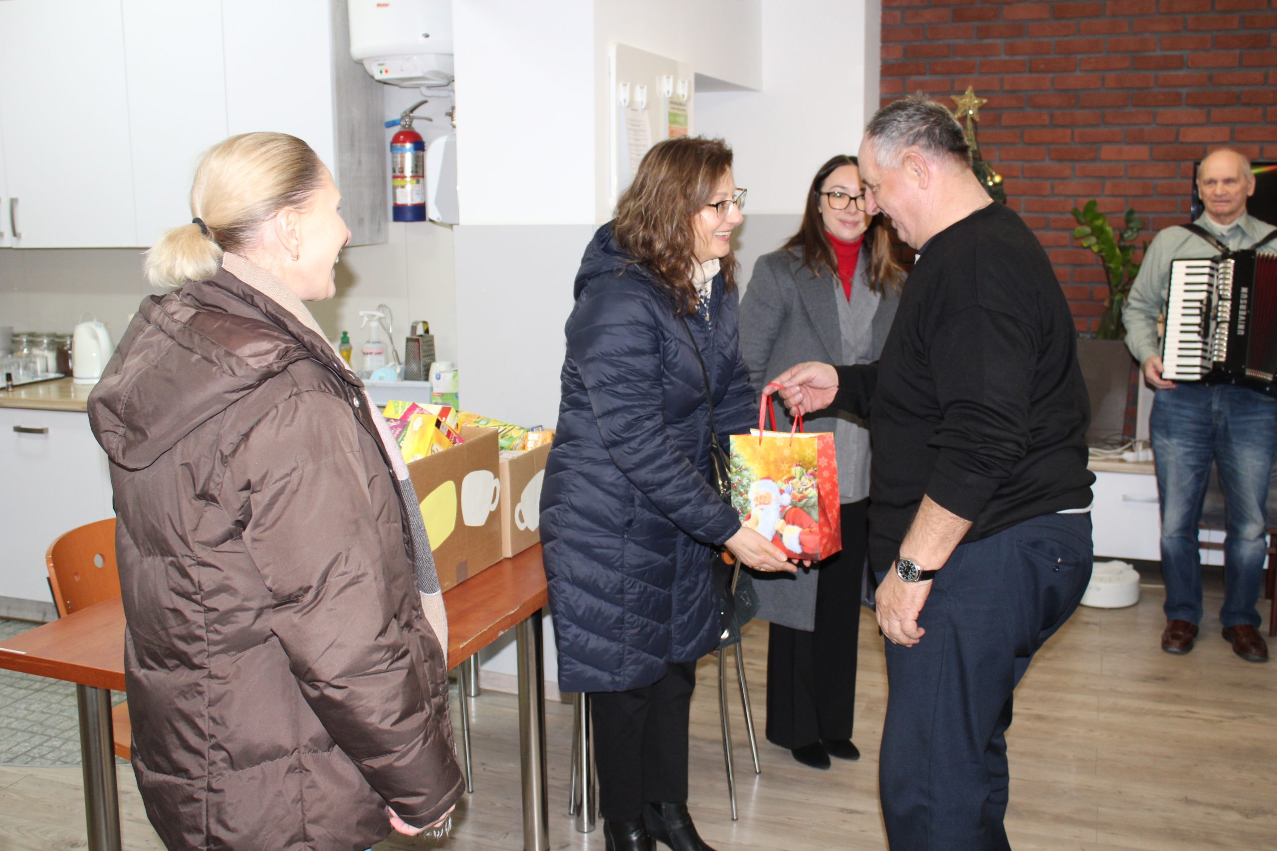 2) Na fotografii jeden z seniorów przekazuje słodkości dla dzieci ze szkoły w Mąkolnie