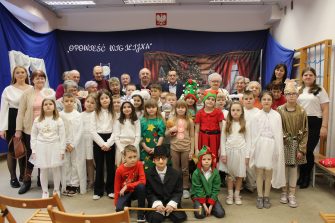 Zdjęcie grupowe uczniów klas drugich ze SP im. Pierwszej Kadrowej w Mąkolnie wraz z uczestnikami Domu Dziennego Pobytu Senior + w Sompolnie. Wykonane po zakończeniu przygotowanej przez dzieci części artystycznej