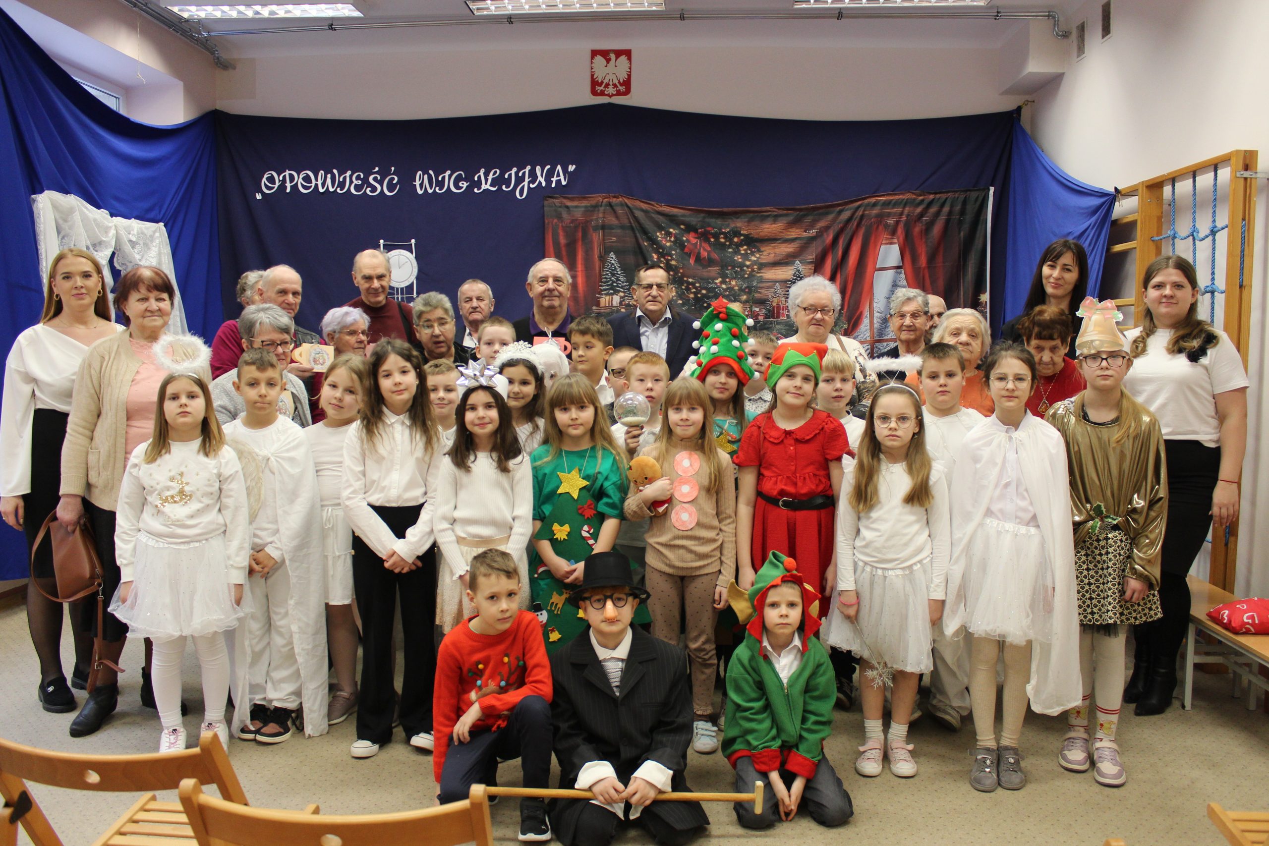 Zdjęcie grupowe uczniów klas drugich ze SP im. Pierwszej Kadrowej w Mąkolnie wraz z uczestnikami Domu Dziennego Pobytu Senior + w Sompolnie. Wykonane po zakończeniu przygotowanej przez dzieci części artystycznej