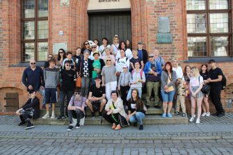 1) Zdjęcie grupowe przedstawiające wszystkich uczestników wycieczki do Torunia. Wykonane na schodach Domu Mikołaja Kopernika.