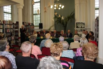 1. Zdjęcie wykonane w sali MGBP w Sompolnie. Przedstawia lektorów tegorocznego narodowego czytania, wśród nich Dyrektor MGBP w Sompolnie przemawiająca do zgromadzonych gości.