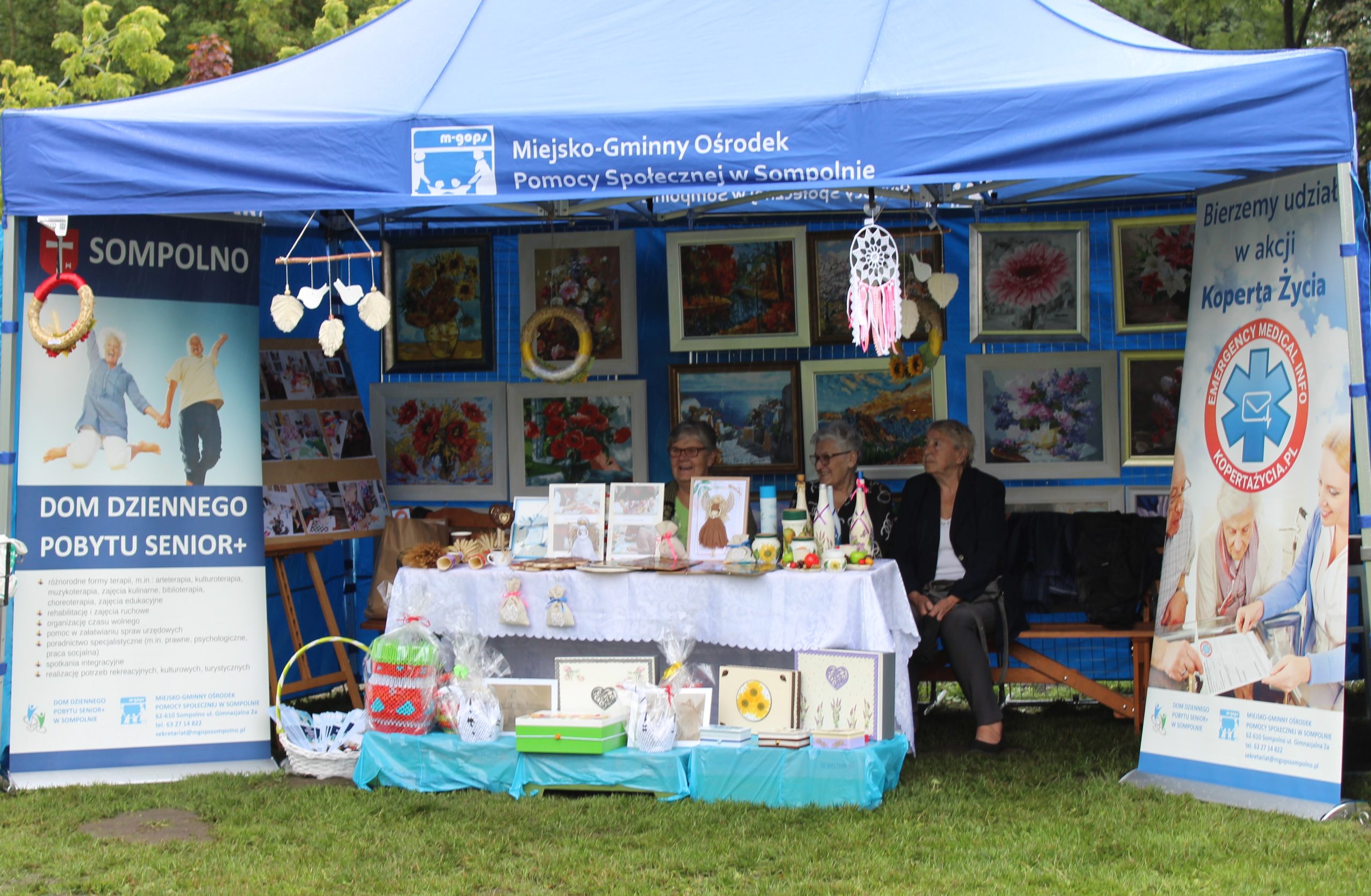 1) Fotografia wykonana w parku przy ulicy 11 Listopada. Prezentuje namiot Miejsko – Gminnego Ośrodka Pomocy Społecznej w Sompolnie pod którym znajduje się stoisko Domu Dziennego Pobytu.