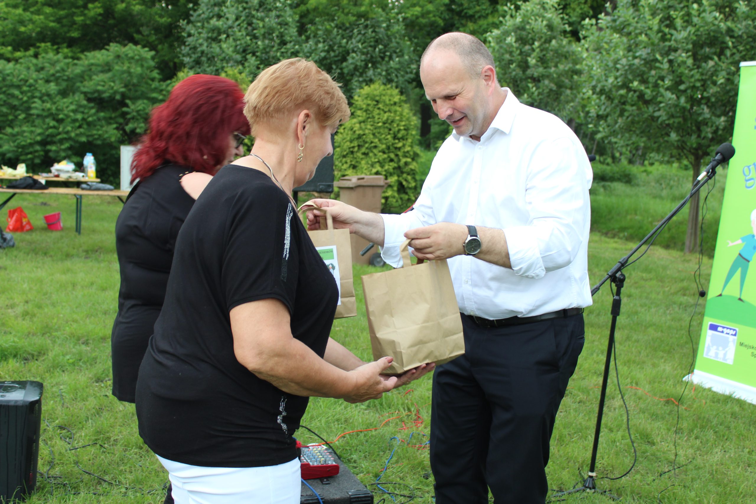 10. Na fotografii burmistrz wręczający nagrody dla dwóch seniorek.