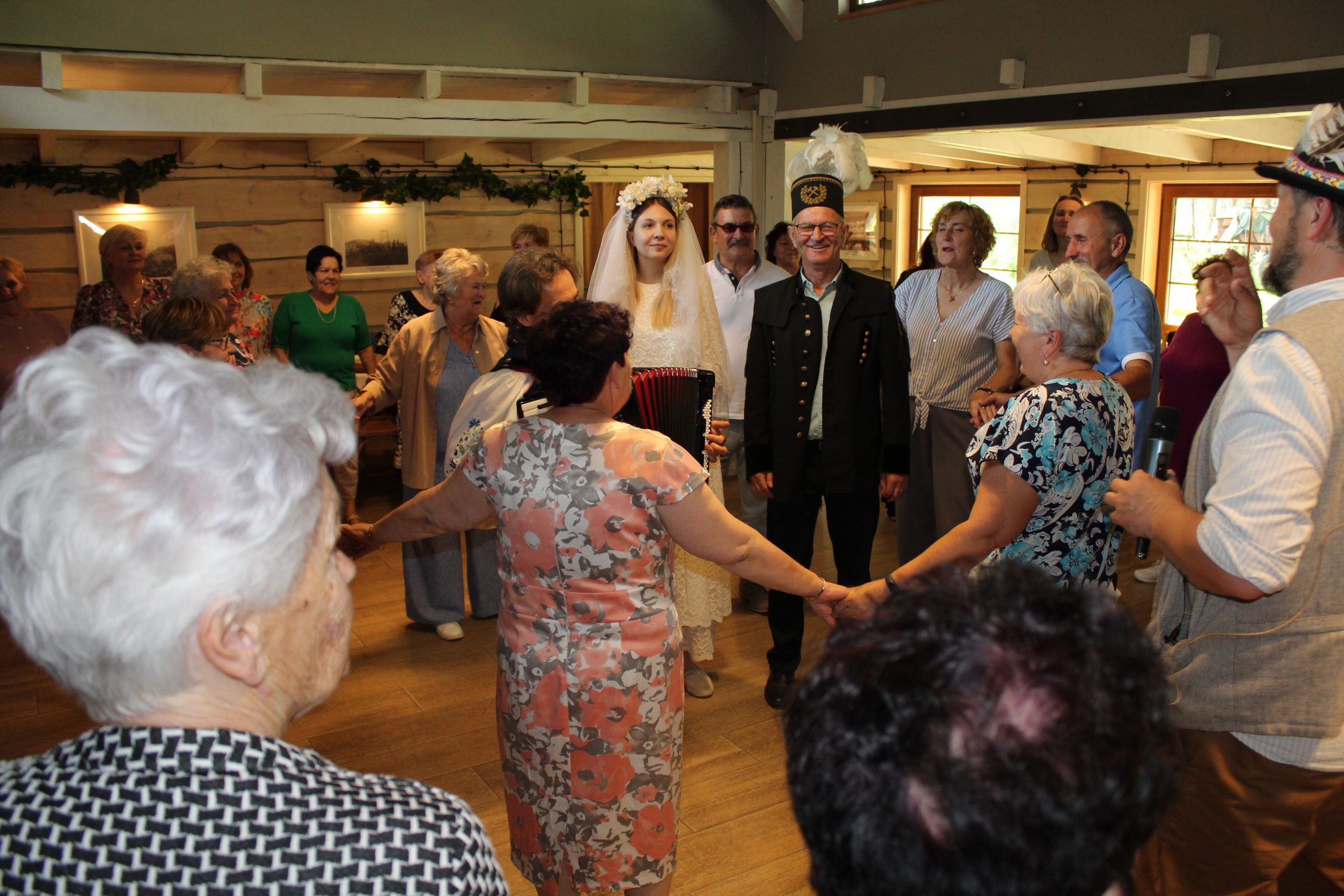 11) Zdjęcie przedstawia gości weselnych tańczących wokół pary młodej.