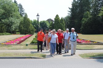 12) Grupa zwiedzających spaceruje pośród dywanów kwiatowych