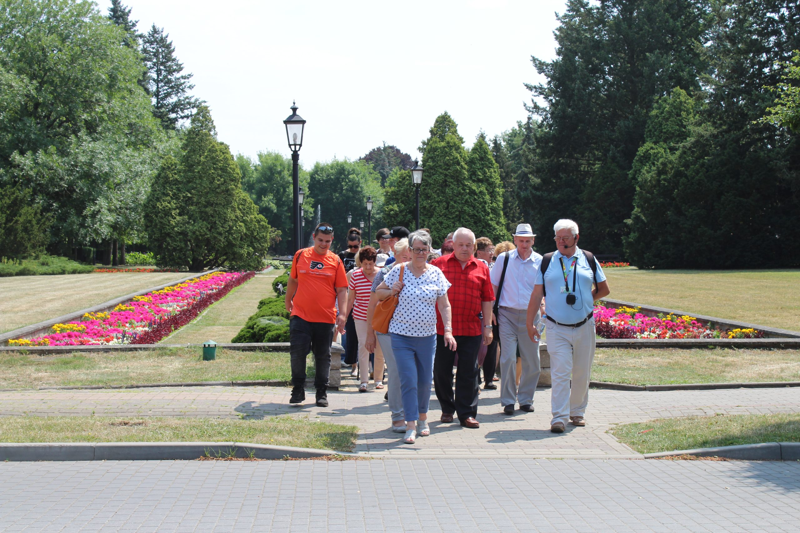 12) Grupa zwiedzających spaceruje pośród dywanów kwiatowych