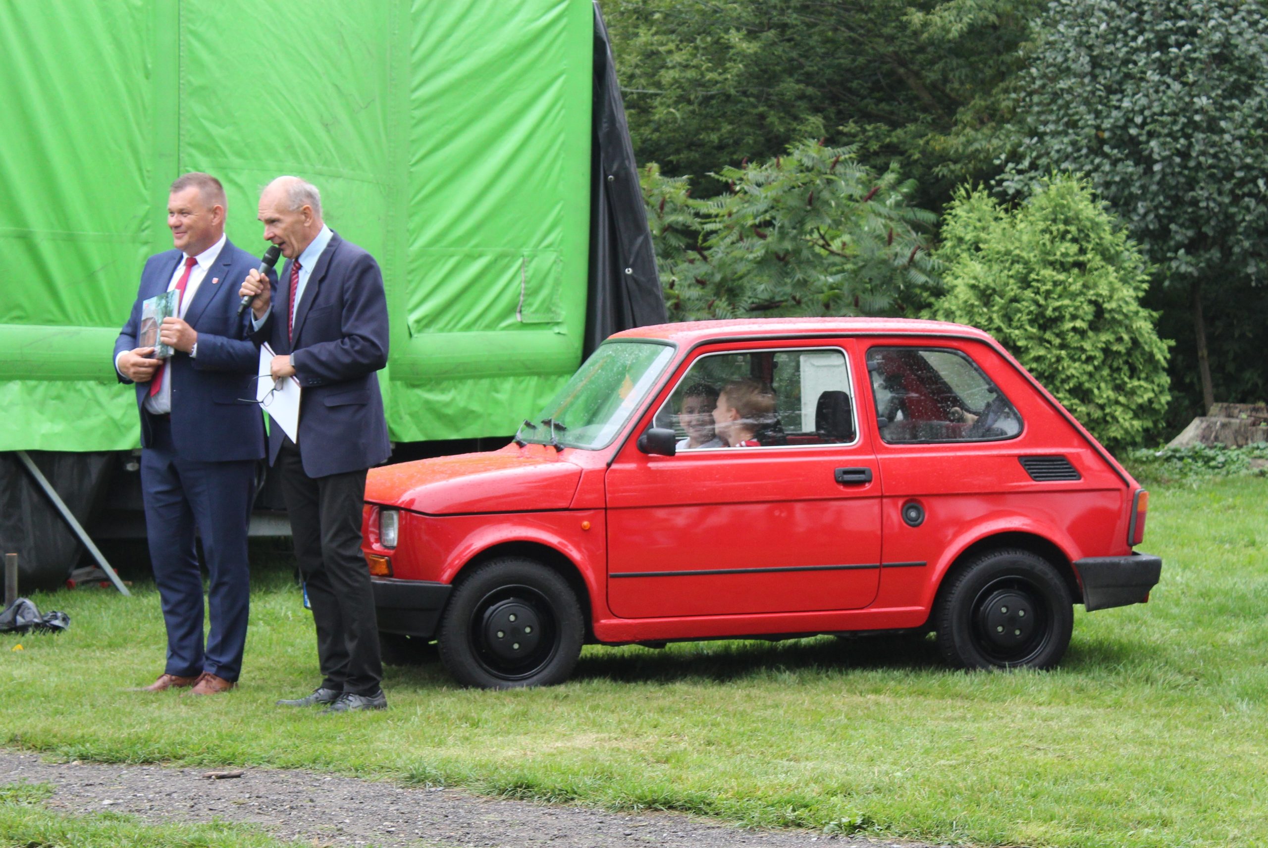14) Na zdjęciu Pan Roman Bednarek oraz Andrzej Prętnicki stojący obok czerwonego malucha.