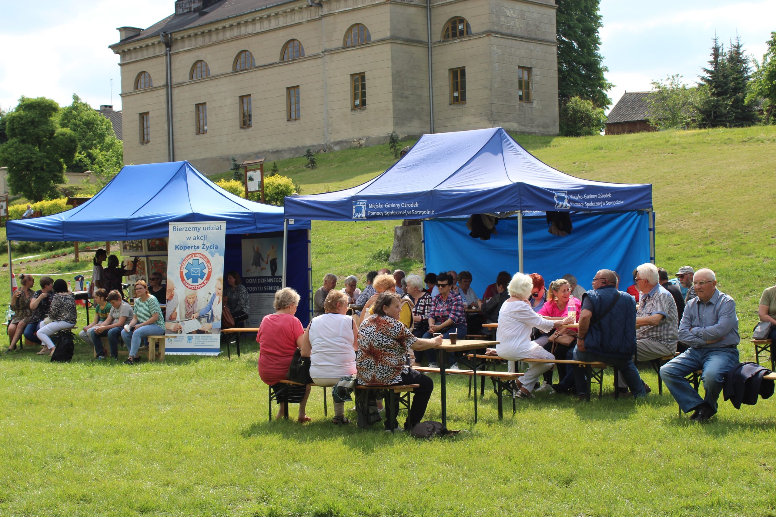 16) Zdjęcie przedstawia namioty MGOPS. W tle kościół ewangelicko – augsburski.