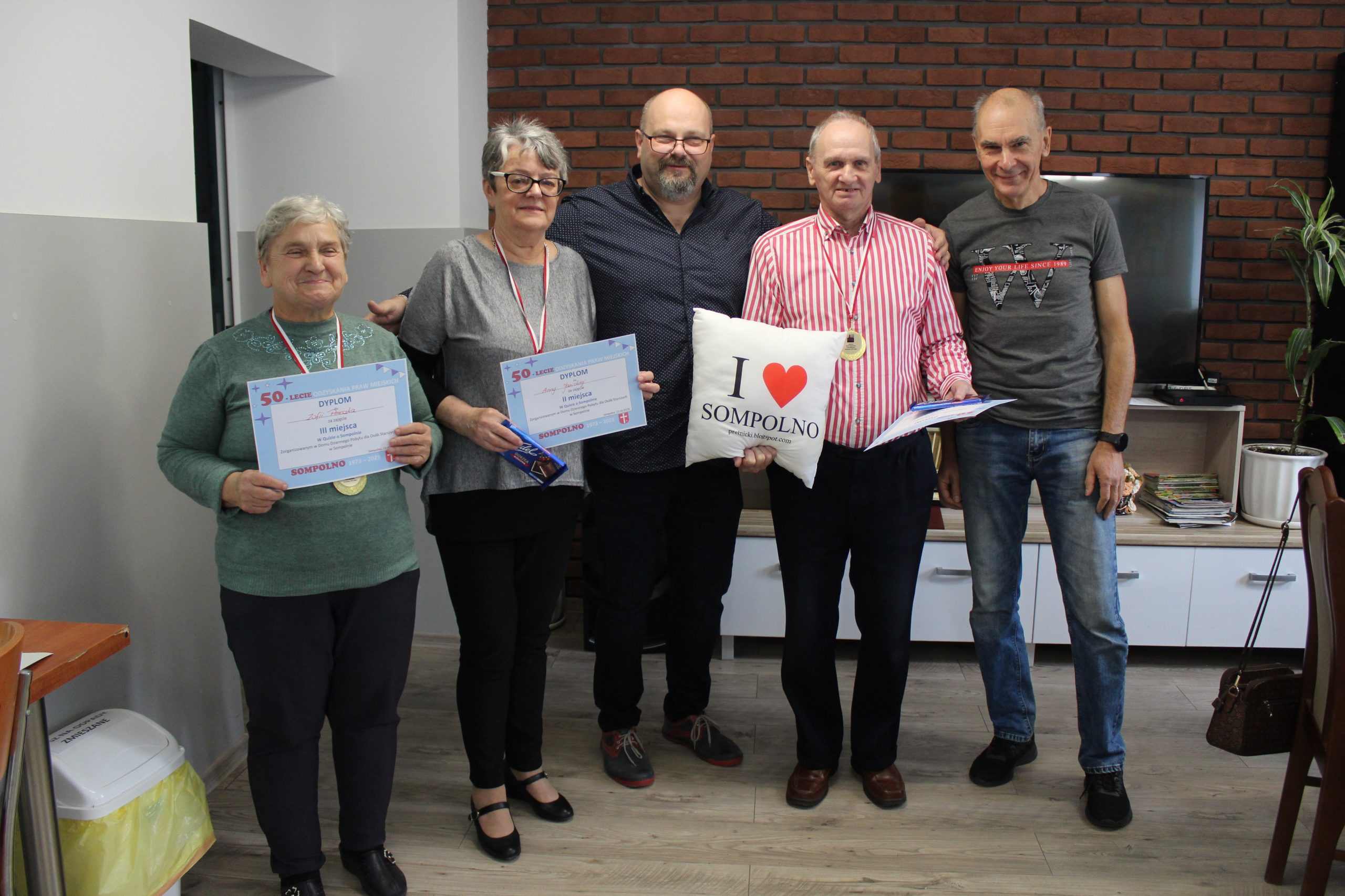 1) Na zdjęciu trójka laureatów quizu o Sompolnie, pozujących do zdjęcia z dyrektorem M-GOPS Tomaszem Majewskim oraz pomysłodawcą quizu – Andrzejem Prętnickim.