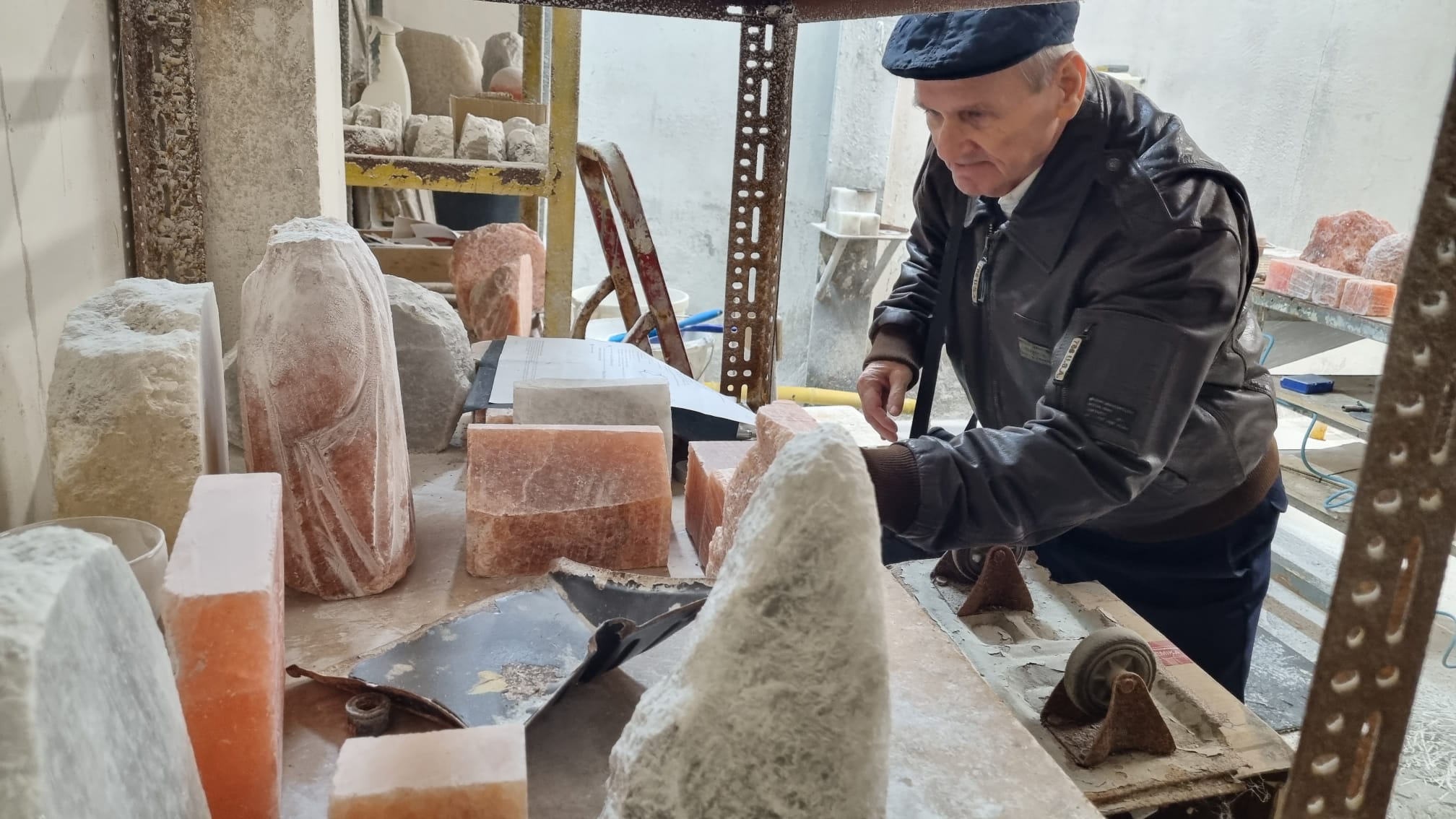 3) Na fotografii starszy mężczyzna przygląda się bryłom soli przed obróbką.