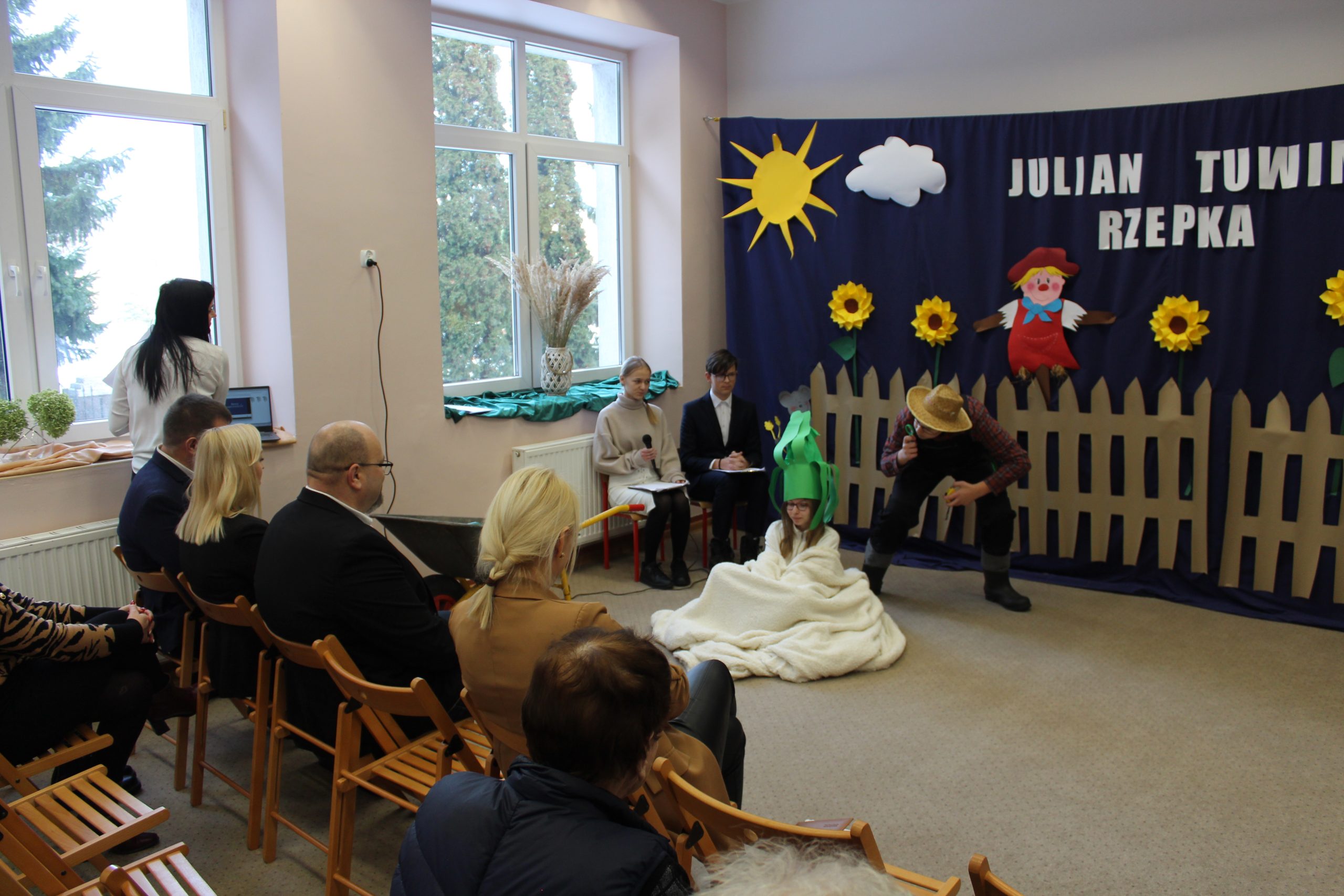 3) Zdjęcie przedstawia młodego człowieka przebranego za ogrodnika przyglądającego się dziewczynie przebranej za rzepkę