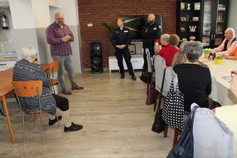 3) Na zdjęciu widzimy grupę Seniorów z Domu Dziennego Pobytu, Dyrektora MGOPS w Sompolnie oraz policjantów przemawiających na sali Głównej do zgromadzonych.
