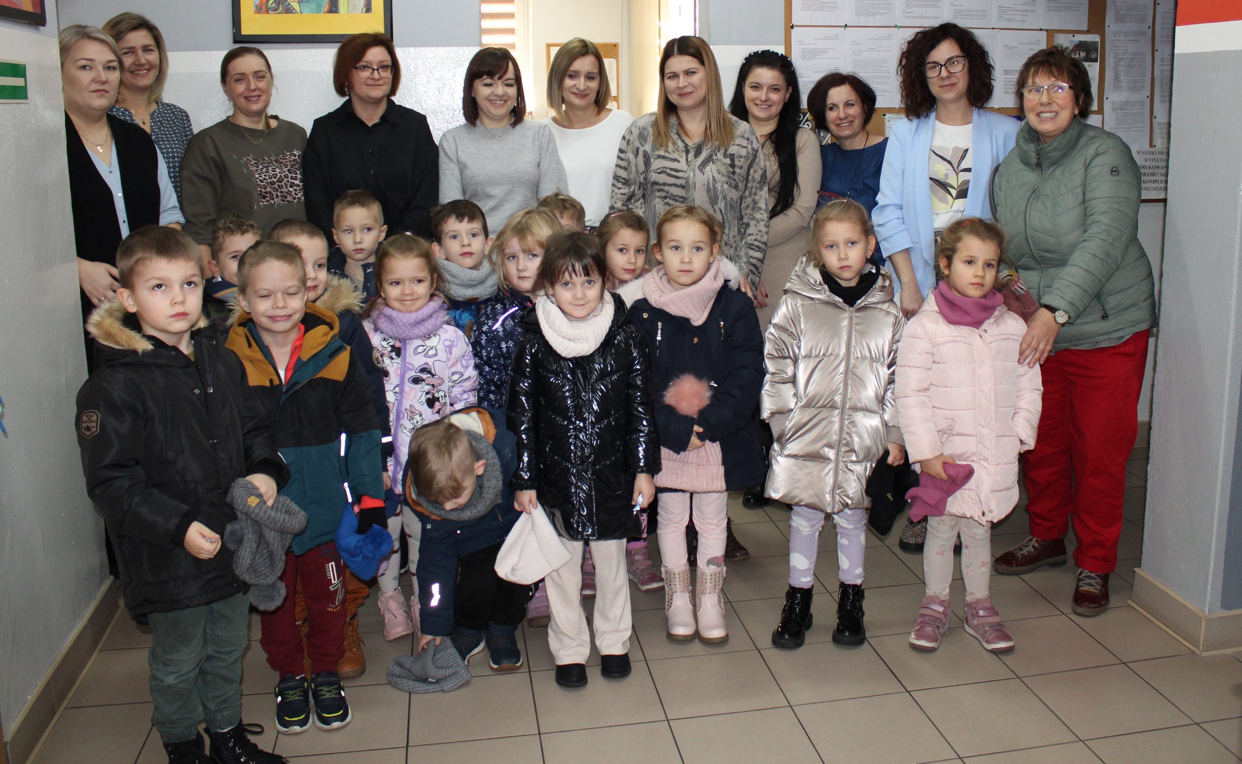 3) Zdjęcie grupowe przedstawia pracowników socjalnych wraz z dziećmi z przedszkola.