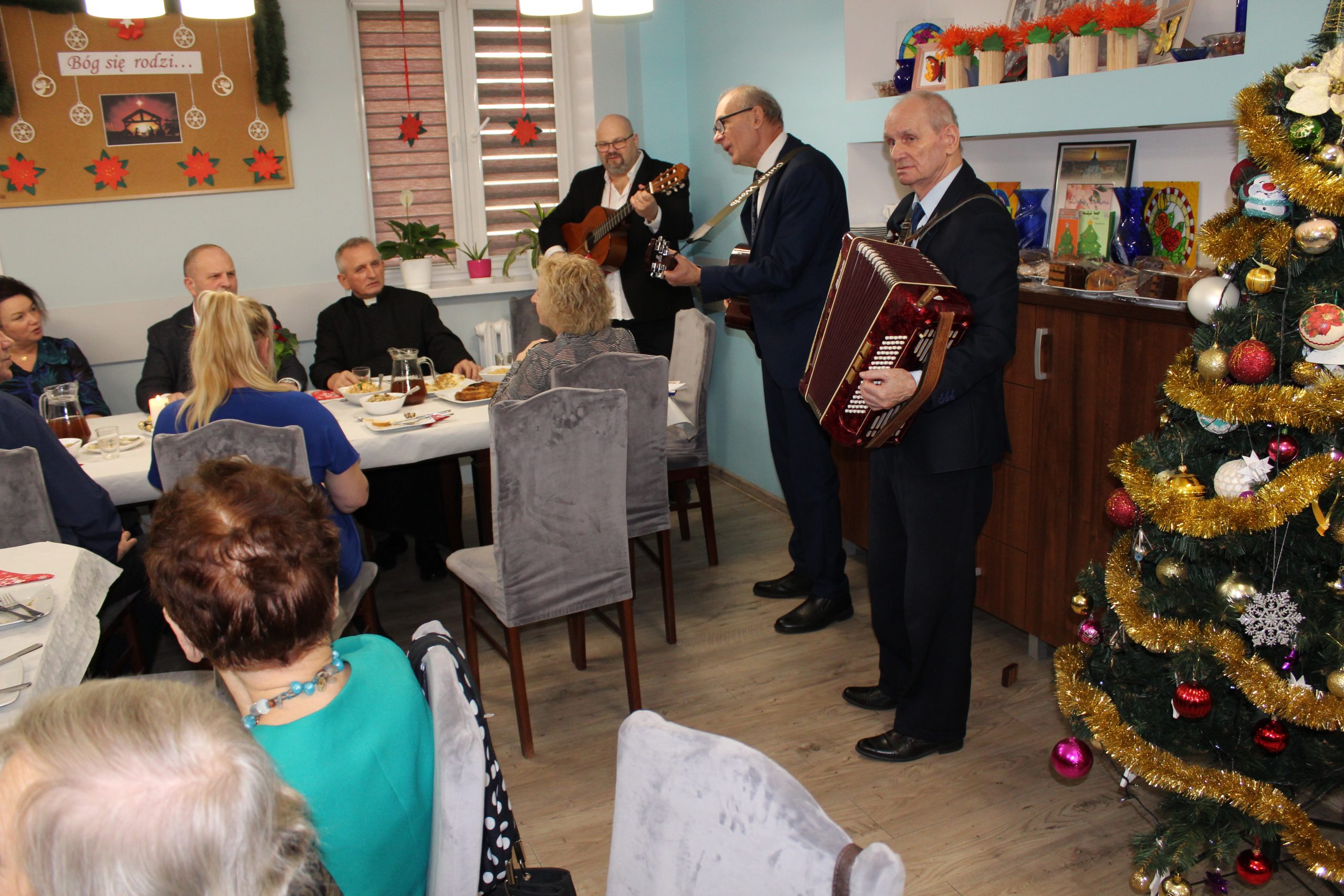 4) Zdjęcie przedstawia kolędujących uczestników spotkania wigilijnego