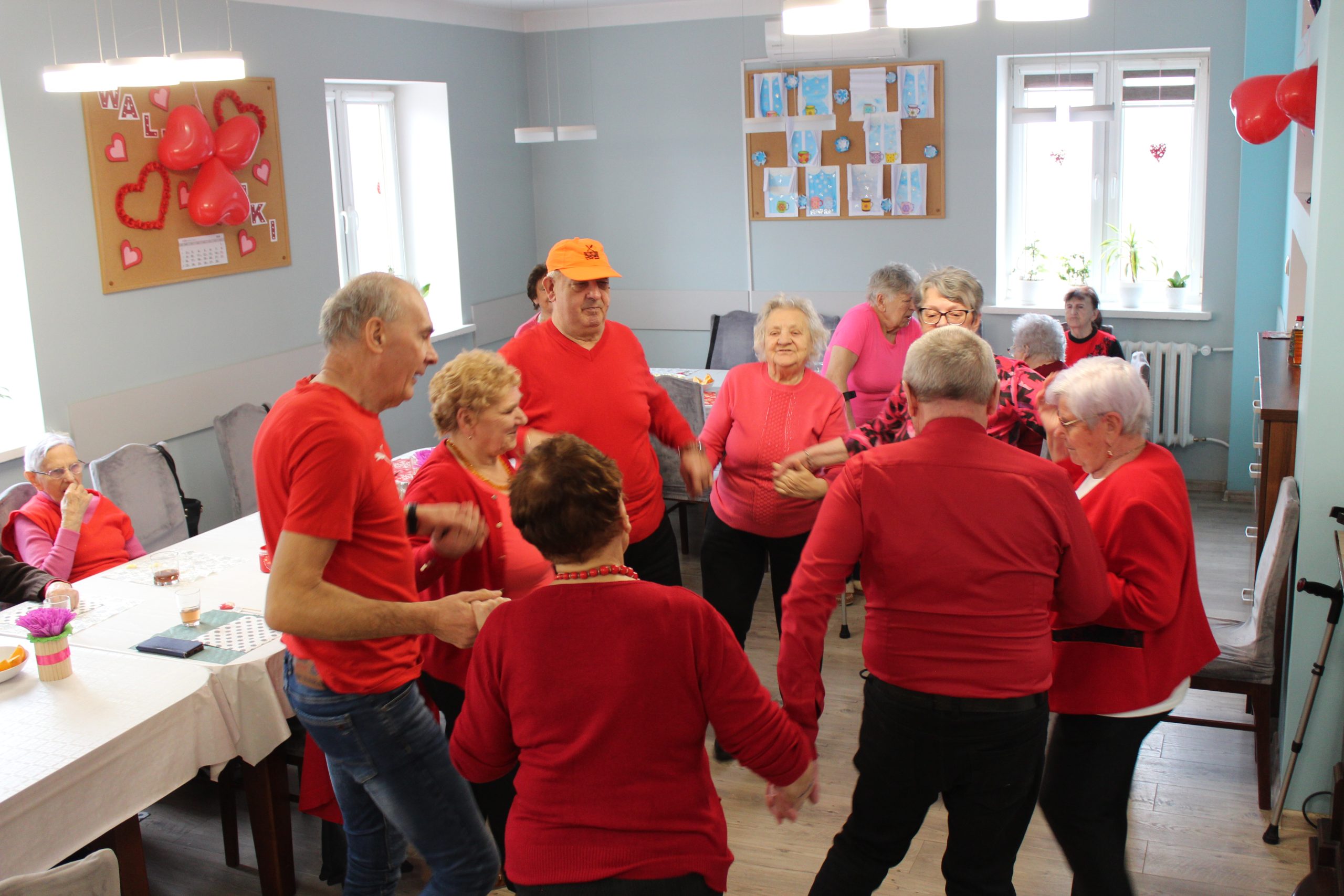 Na zdjęciu seniorzy tańczący w kółku podczas balu karnawałowego