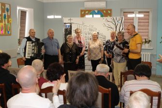 5) Zdjęcie przedstawia ośmioro aktorów grających w sztuce. Publiczność bije brawa.