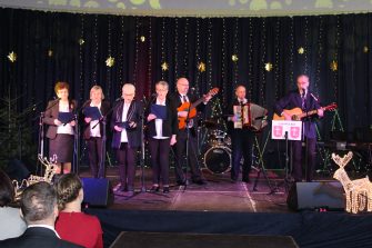 2) Na zdjęciu reprezentacja domu dziennego pobytu. Za nimi rozciąga się granatowa kotara ze złotymi gwiazdami.