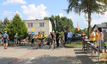 3) Na zdjęciu uczestnicy rajdu parkujący swoje rowery na parkingu MGOPS. Po prawej stronie pracownicy ośrodka przygotowujący posiłki z grilla.