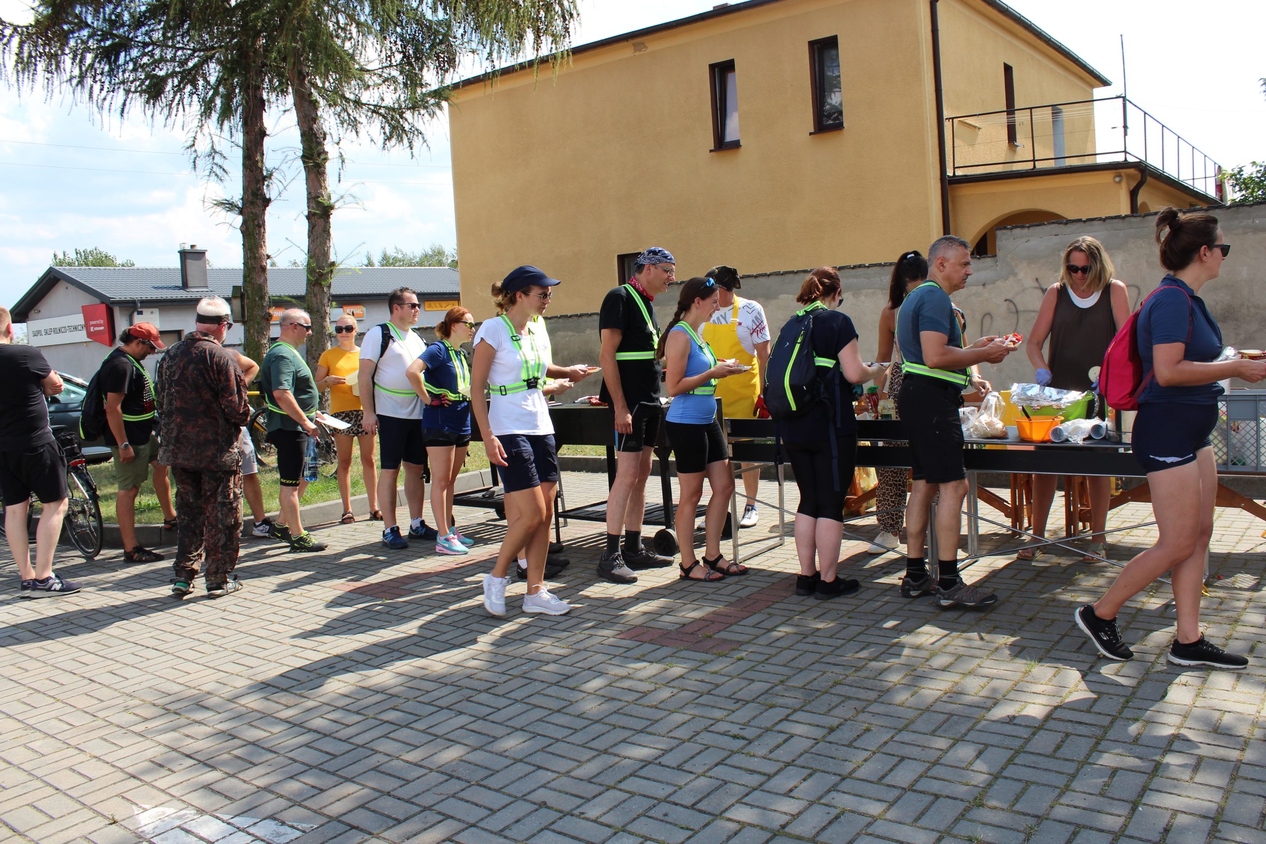 4) Na fotografii uczestnicy rajdu rowerowego częstowani posiłkami z grilla.