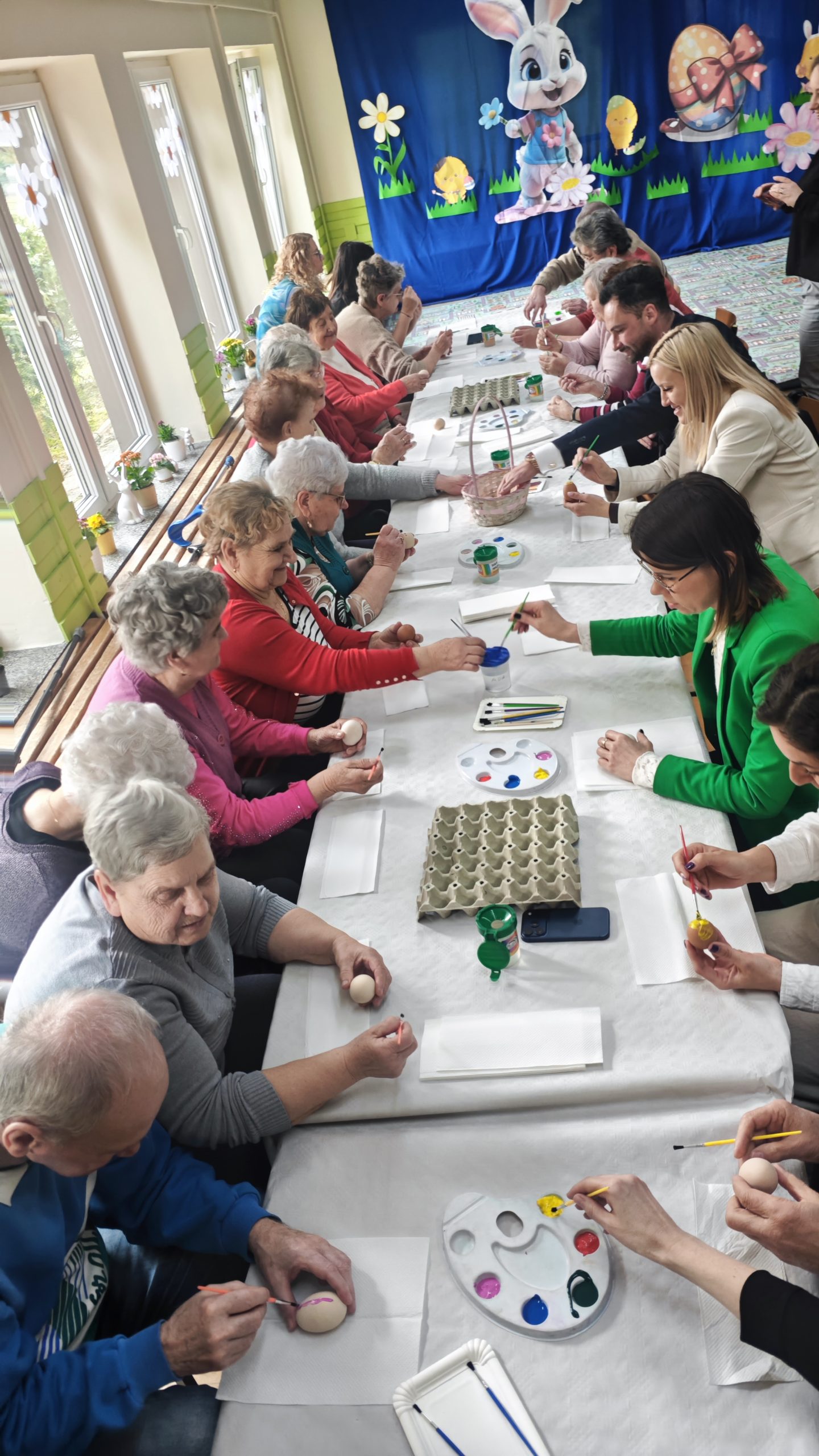 3. Fotografia wykonana podczas warsztatów plastycznych o tematyce wielkanocnej na których seniorzy ozdabiają jajka wielkanocne.