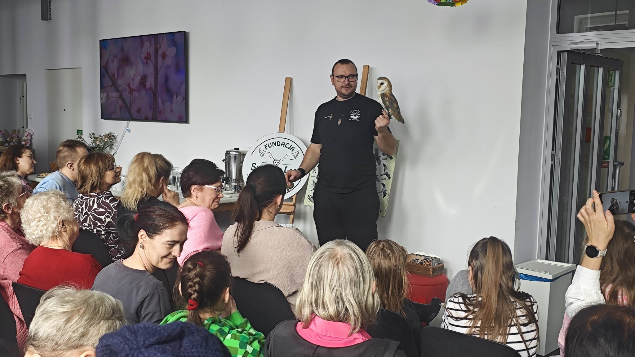 3) Pan Piotr prezentuje płomykówkę. Na zdjęciu licznie zgromadzona widownia.