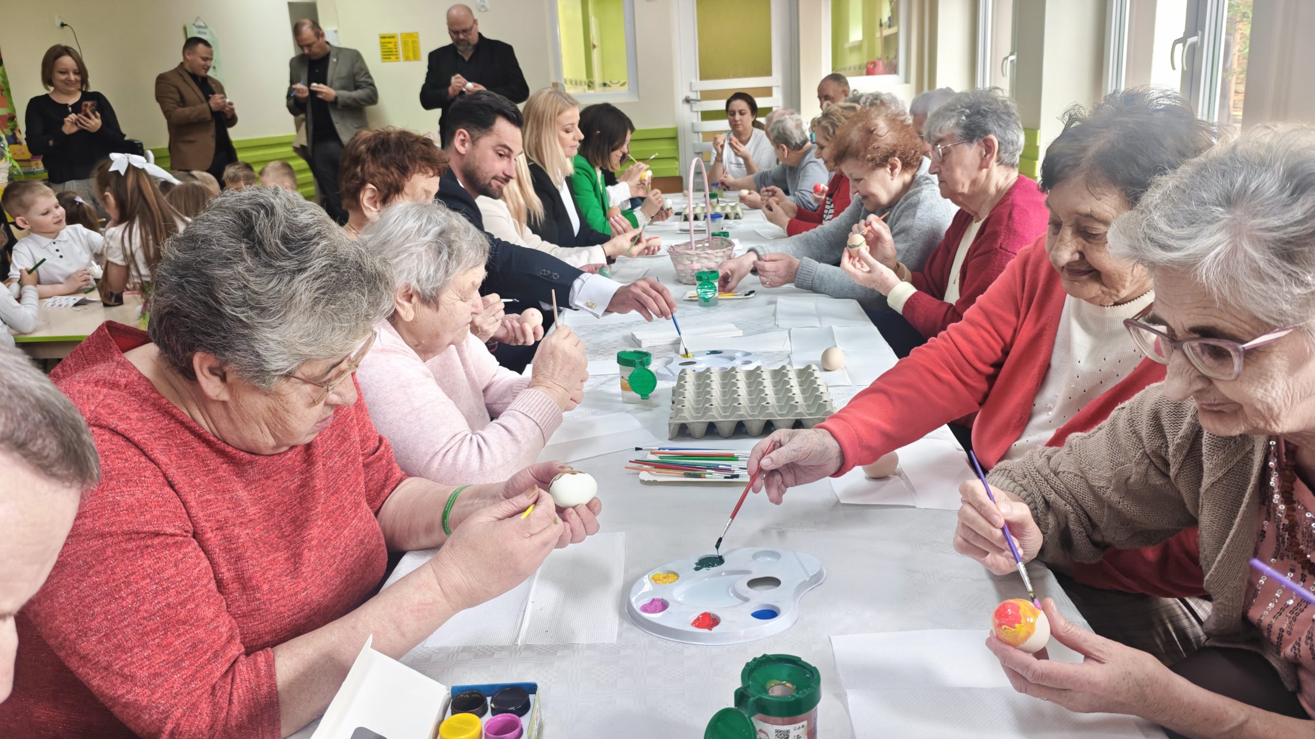 4. Na zdjęciu widać seniorów podczas malowania pisanek.