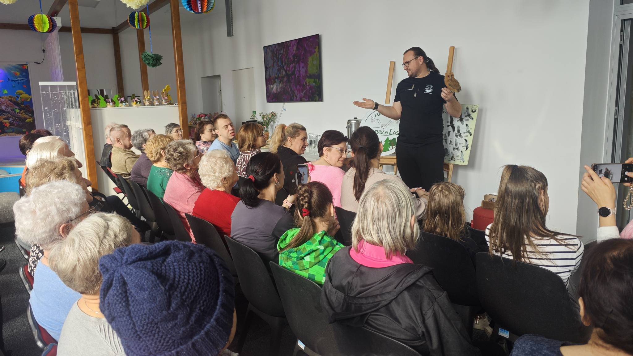 4) Pan Piotr prezentuje małą rudą sowę. Na zdjęciu licznie zgromadzona widownia.