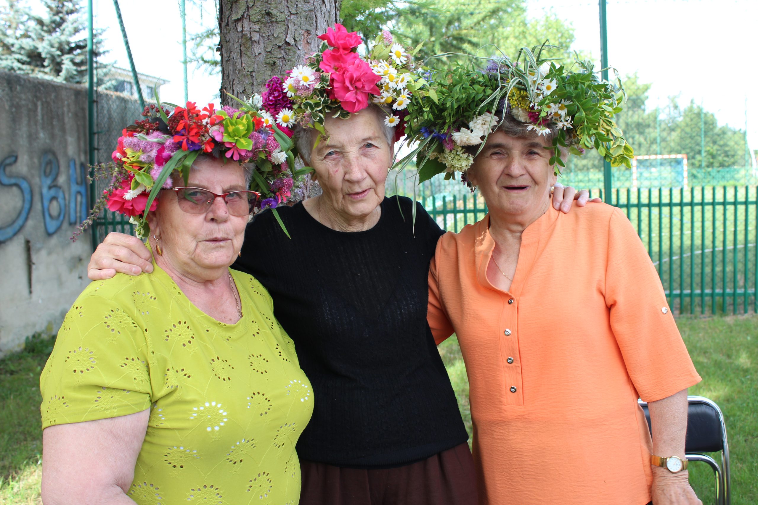 3) Na zdjęciu trzy seniorki z własnoręcznie wykonanymi wiankami na głowach.