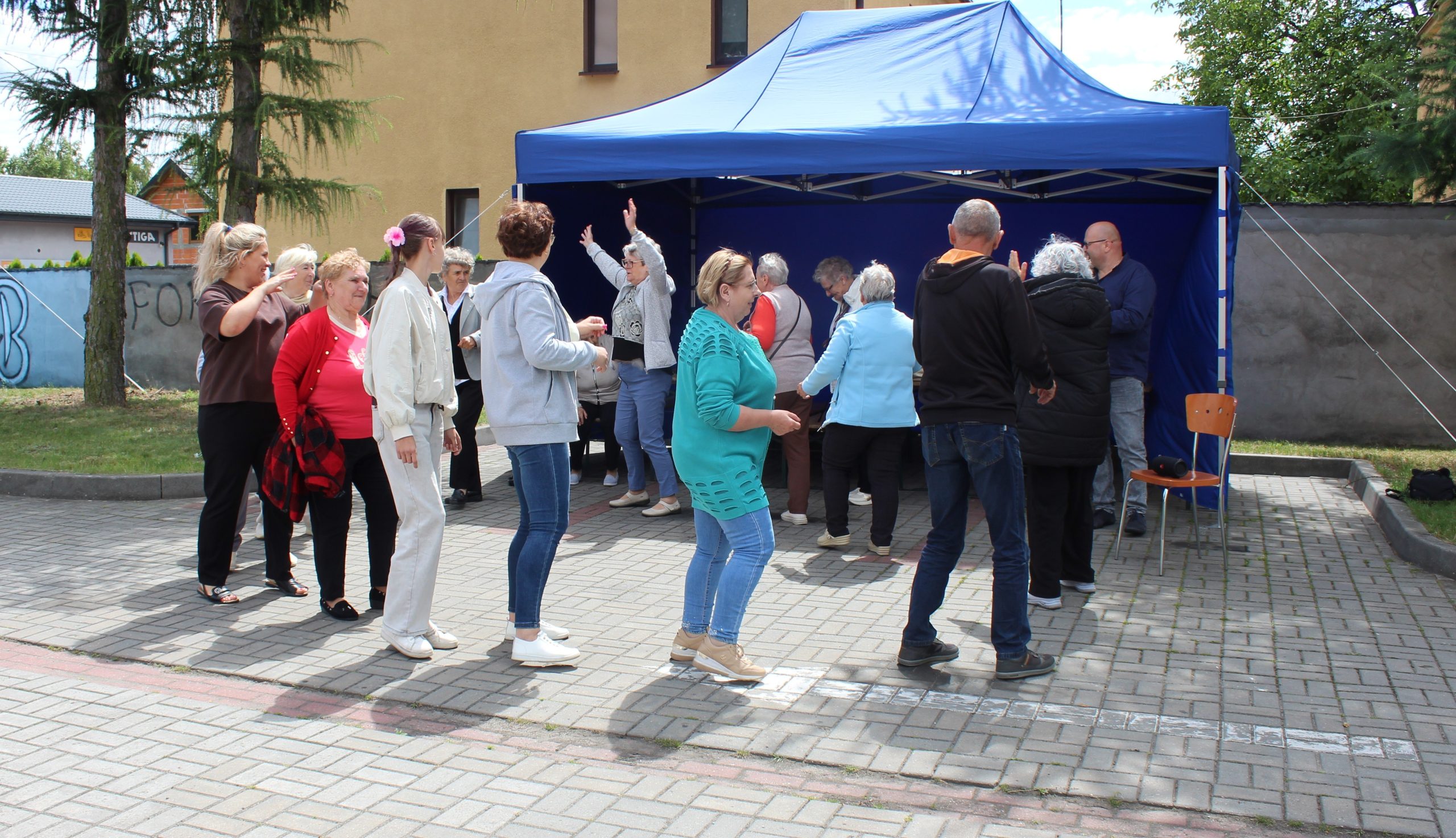 Na fotografii seniorzy tańczący podczas spotkania przy grillu.