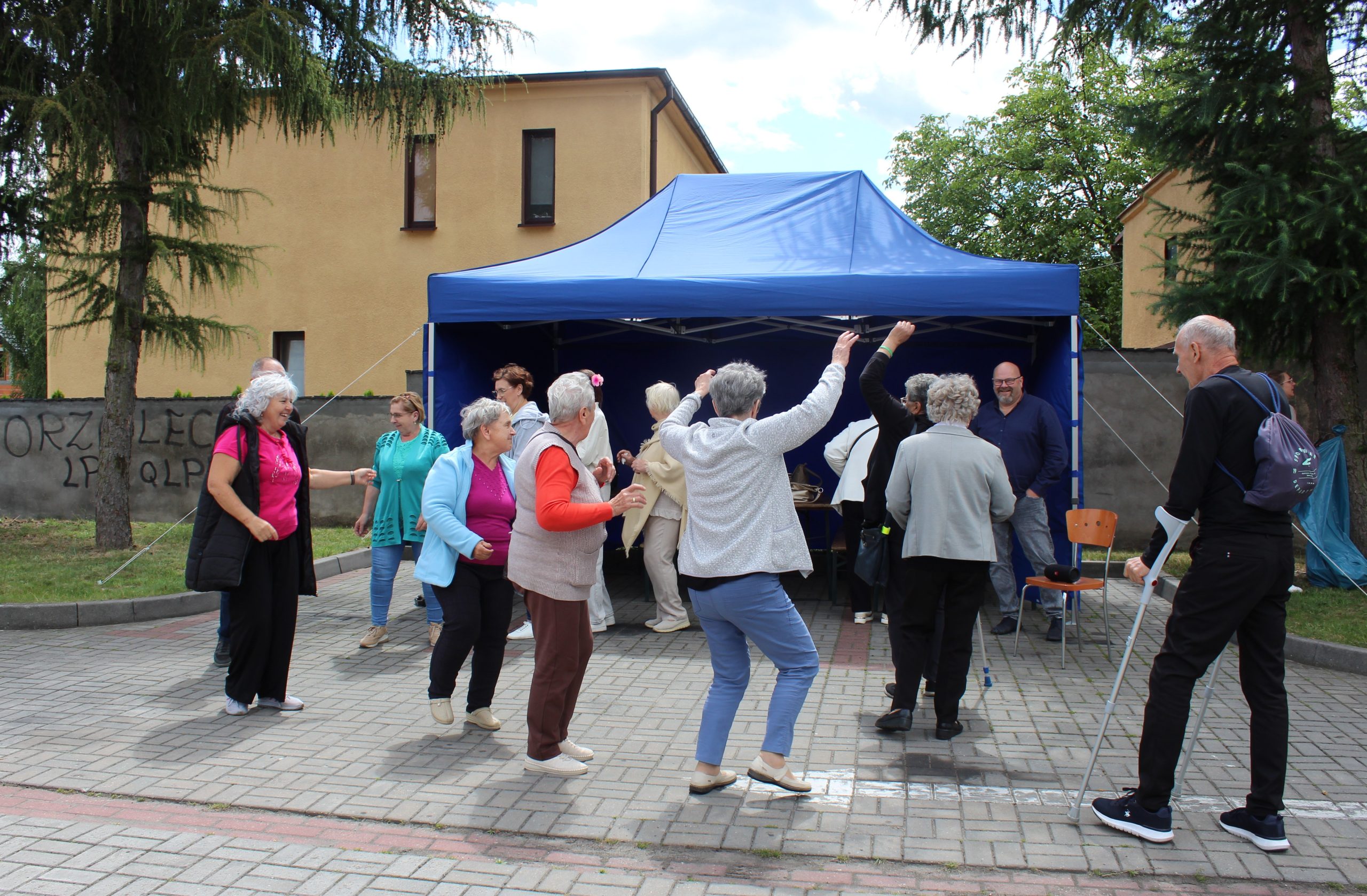 Na fotografii seniorzy tańczący podczas integracyjnego spotkania przy grillu.