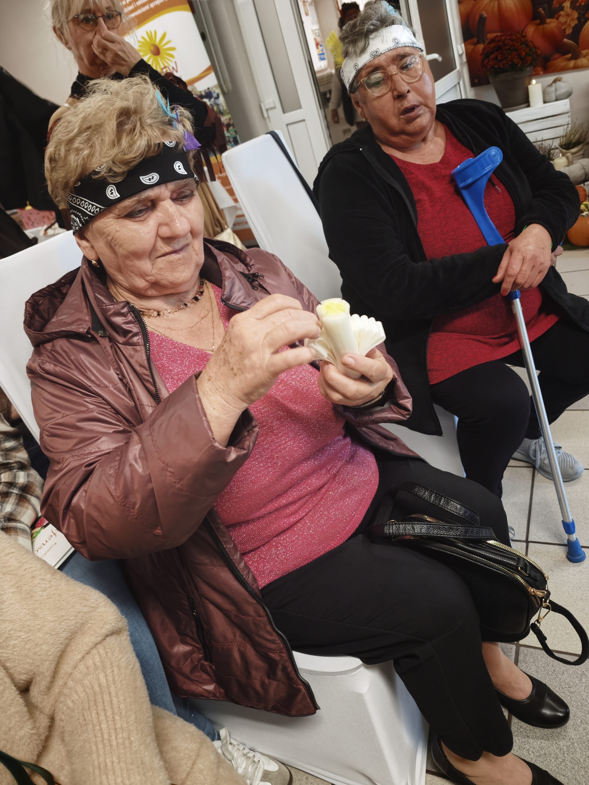4.Zdjęcie przedstawia seniorkę, która samodzielnie wykonuję ozdobę z pora.