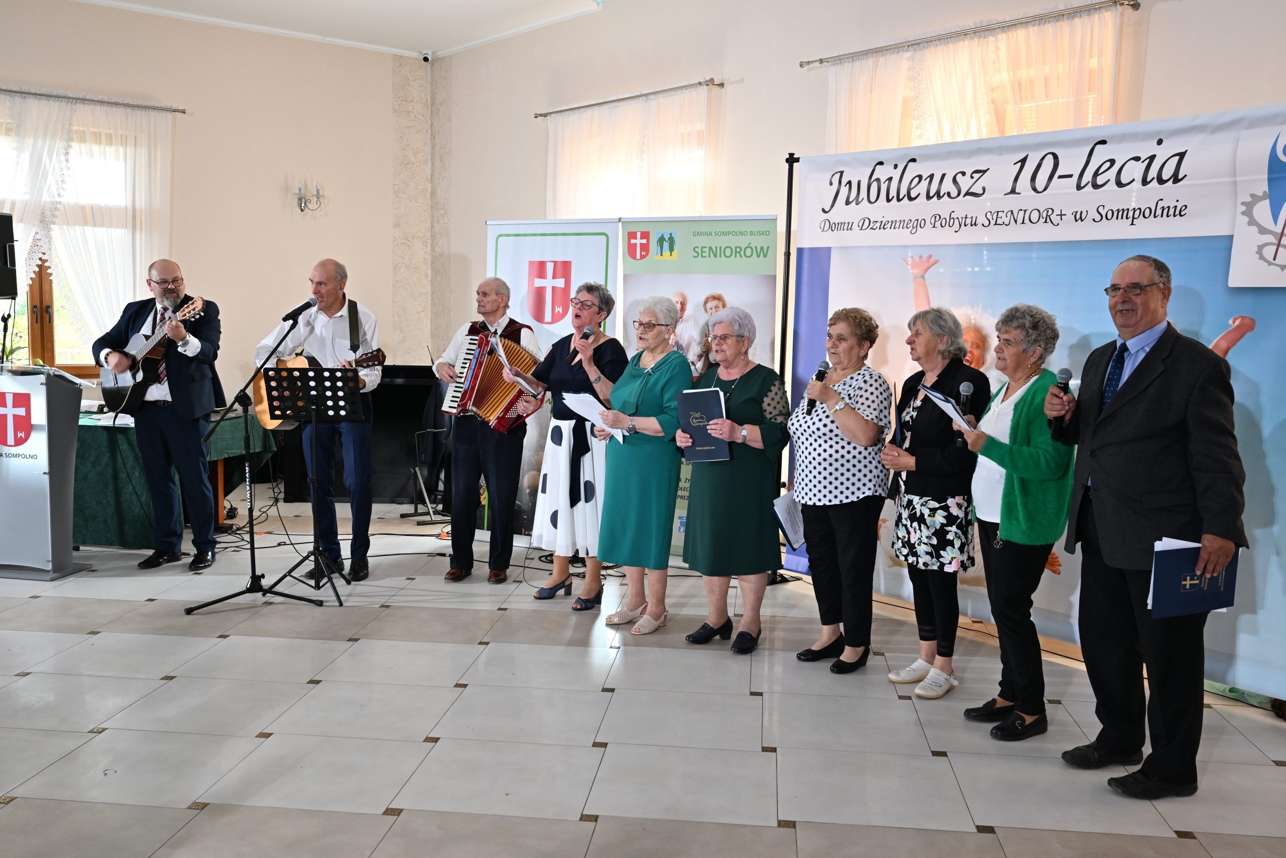 19) Fotografia przedstawia seniorów śpiewających piosenki podczas 10-lecia DDP
